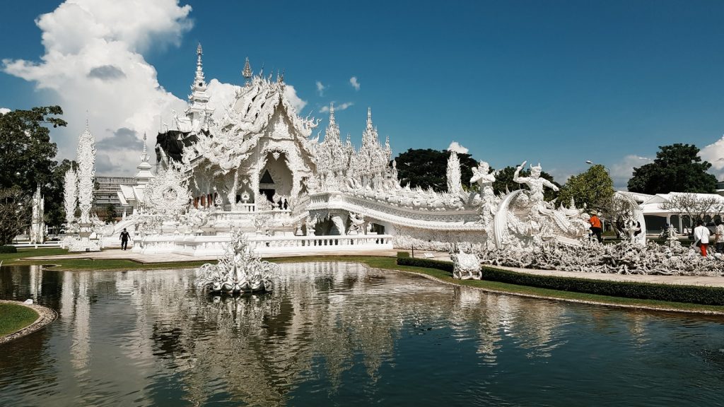 a large white building with a pond in front of it