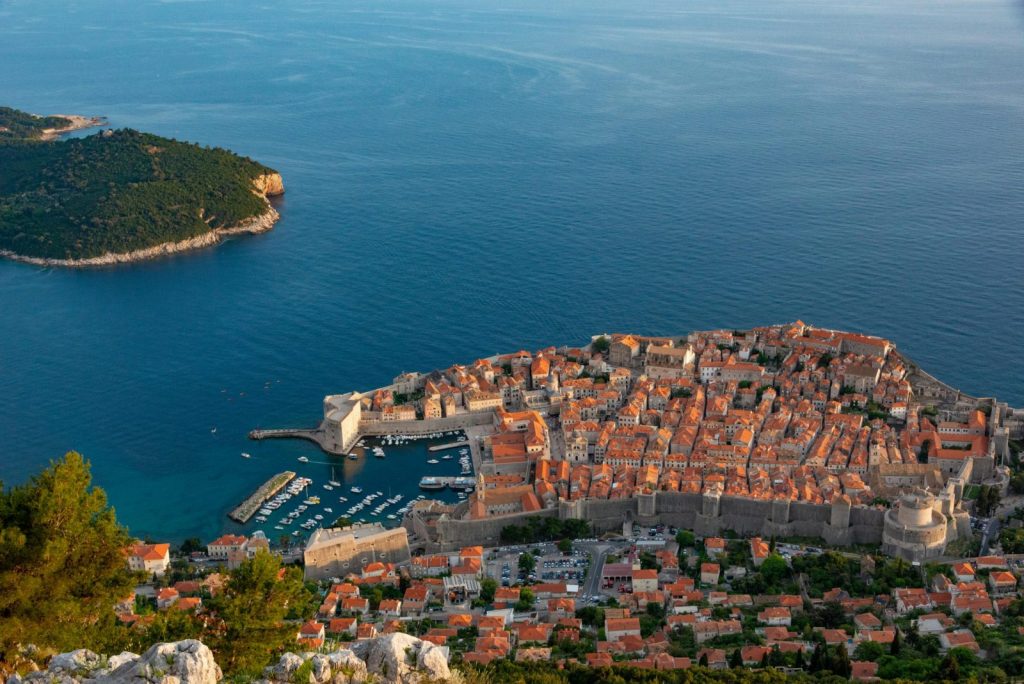 Stunning aerial view of Dubrovnik's old town and harbor, showcasing medieval architecture and Adriatic Sea.