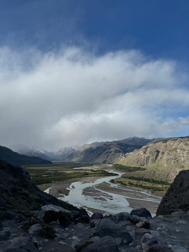 Scenic mountain landscape with winding river and expansive sky in Argentine Patagonia.