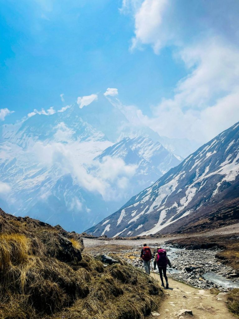 Scenic trek in Ghandruk, Nepal, showcasing majestic Annapurna mountains and adventurous hikers.