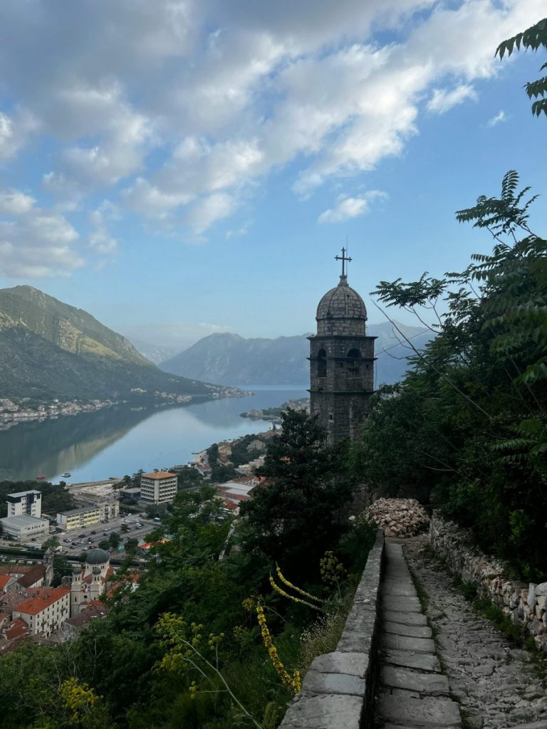 Explore the breathtaking view of Kotor Bay and a historic tower in Montenegro's picturesque Špiljari.