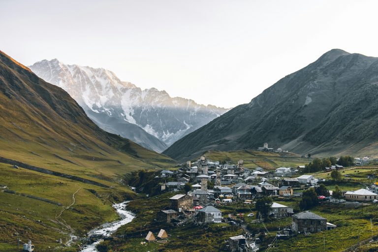 aerial photography of houses beside rocky mountains during daytime