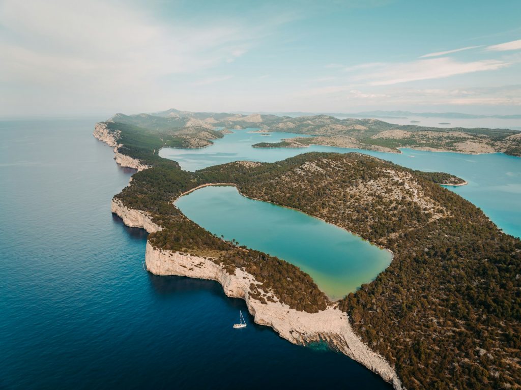 Aerial view of a coastal island and stunning blue waters.